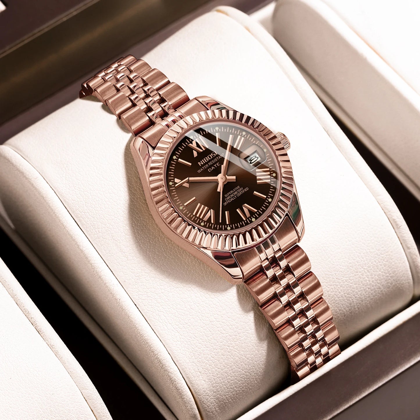 Rose gold watch with a brown dial on a white cushion inside a box
