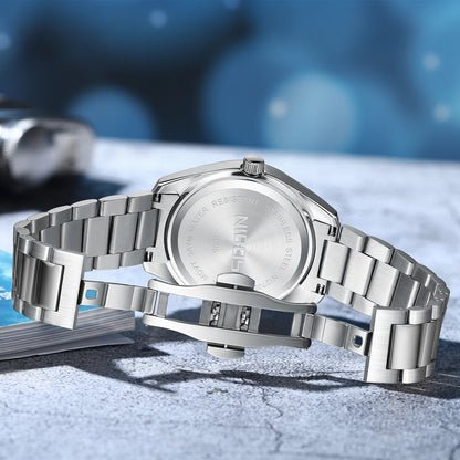 Silver watch with metal band on a textured surface with blue blurred background