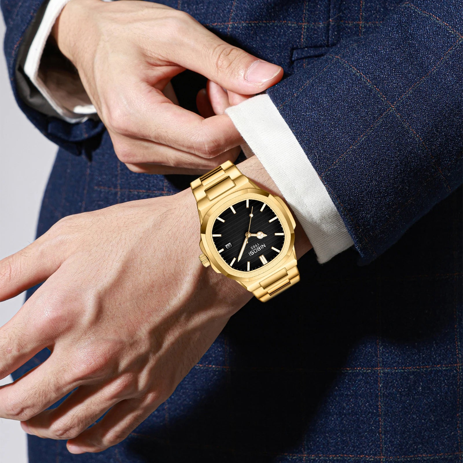 Person wearing a gold watch with a dark face on a blurred background