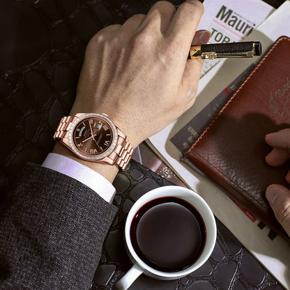 Hand wearing a rose gold watch with a cup of coffee and leather wallet on a textured surface