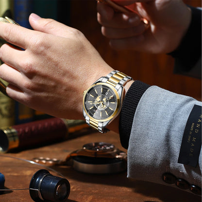 Close-up of a person's wrist wearing a gold and silver watch with a blurred background