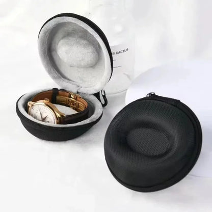 Black hard-shell travel case with a watch inside on a white background