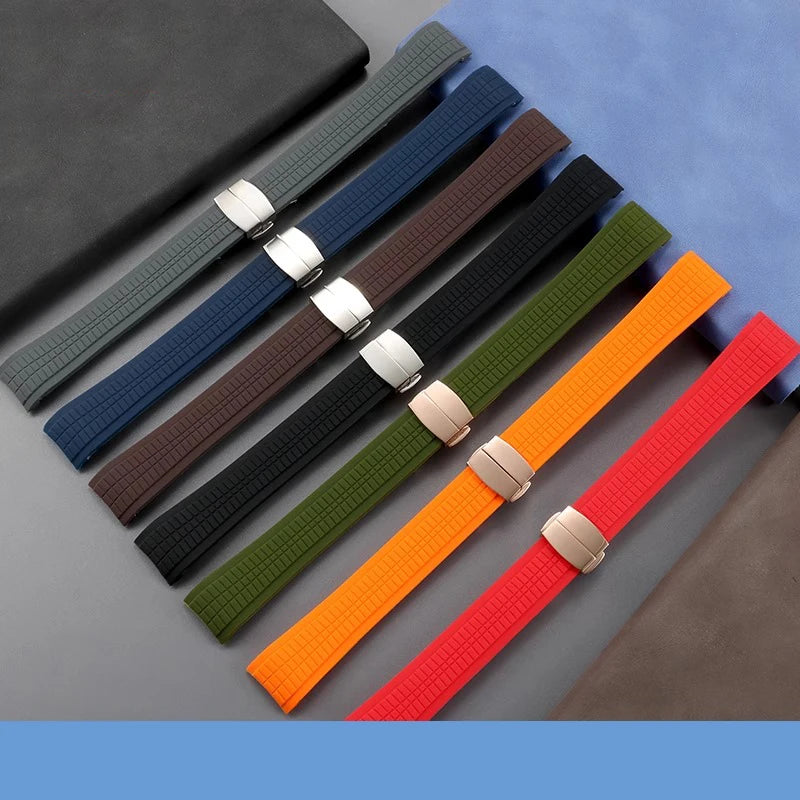 Set of colorful watch straps with metal buckles on a gray surface