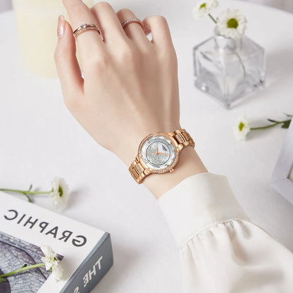 Hand wearing a rose gold watch with a white background